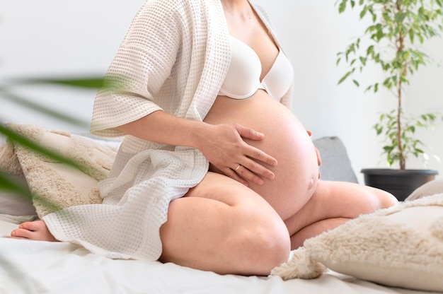 Close up pregnant woman holding tummy