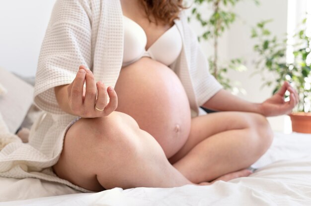 Крупным планом беременная женщина медитирует