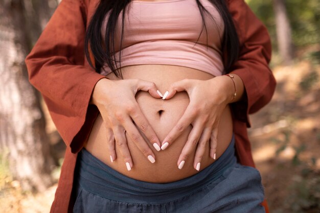 Крупным планом беременная женщина на открытом воздухе