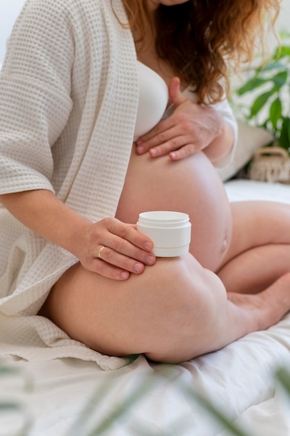 Free photo close up pregnant woman with cream