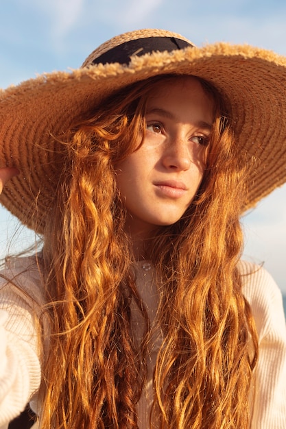 Foto gratuita cappello da portare della ragazza graziosa del primo piano