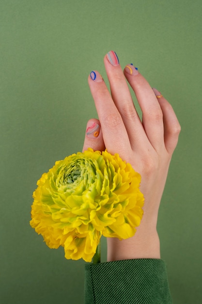 Close up pretty manicure and yellow flower