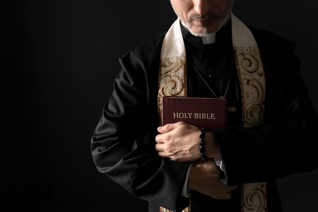 Close up priest holding bible