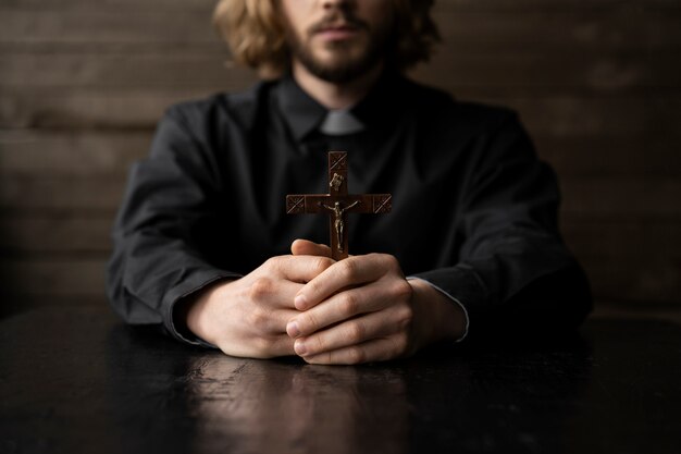 Close up priest holding cross