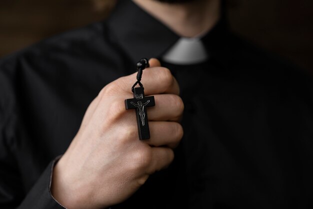 Close up priest holding rosary