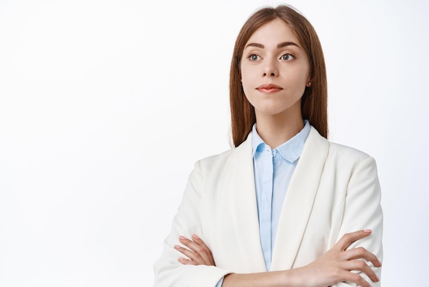 Close up of professional and successful ceo office woman wearing business white suit cross arms on chest look aside at promotional text logo stands over studio background