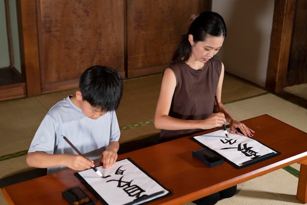 Close up on pupils doing japanese calligraphy, called shodo