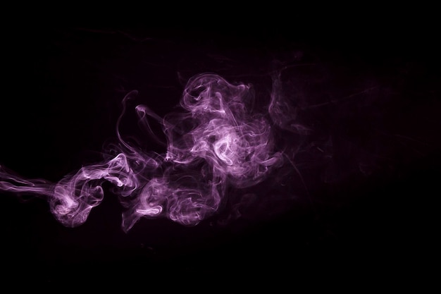Foto gratuita primo piano del disegno viola del fumo del vapore su fondo nero