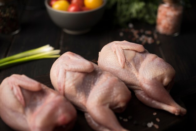 Close-up raw chicken on wooden board with ingredients