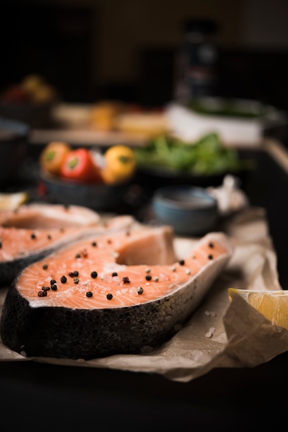 Close-up raw salmon steak with pepper and ingredients