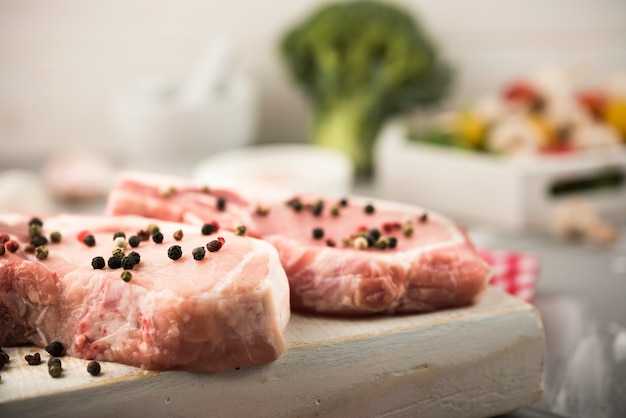 Close-up raw steak on wooden board with veggies