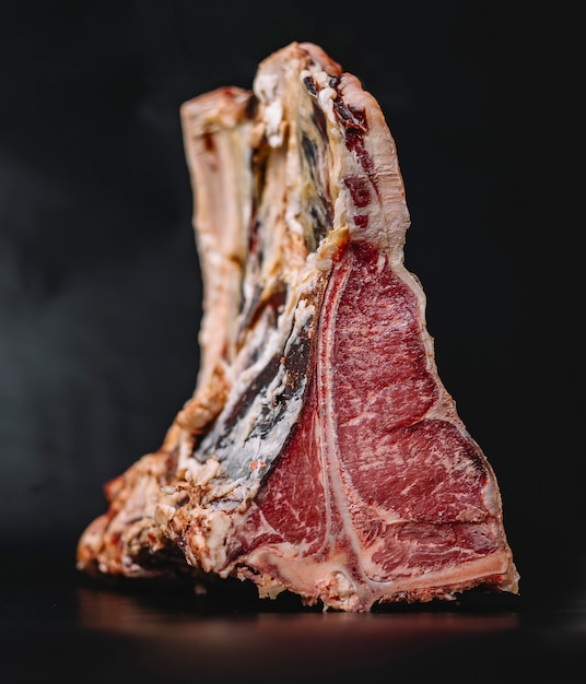 Free photo close up of raw t-bone beef steak placed on navy blue