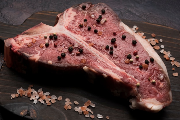 Close-up raw t-bone steak with pepper