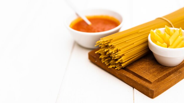 Close-up of raw uncooked pasta and tomato sauce