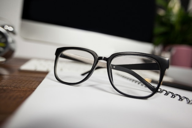 Close- up of reading glasses on office desk