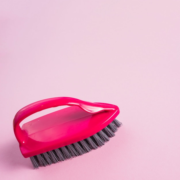 Foto gratuita primo piano della spazzola rossa sulla superficie rosa