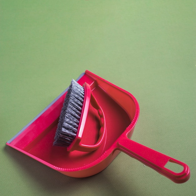 Close-up of red dustpan and brush