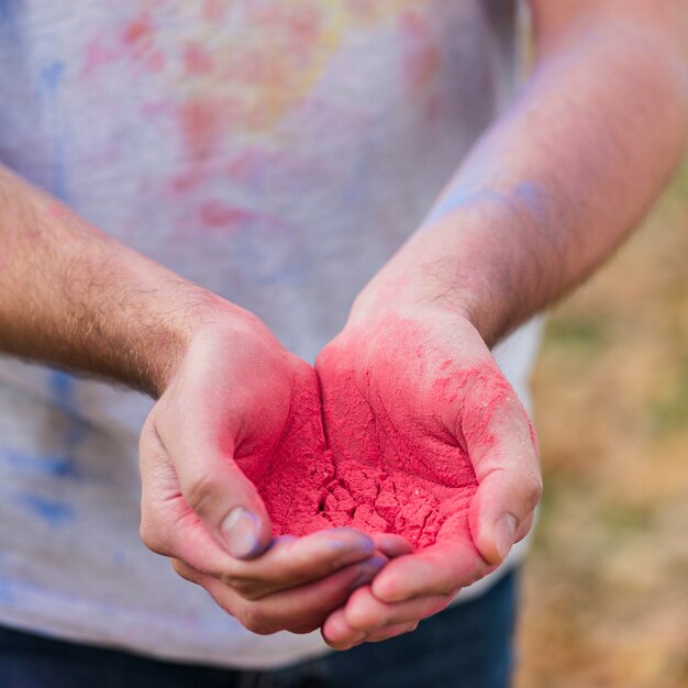 Close-up of red paint held in hands
