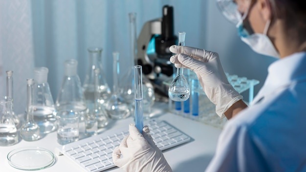 Free photo close-up researcher holding glassware