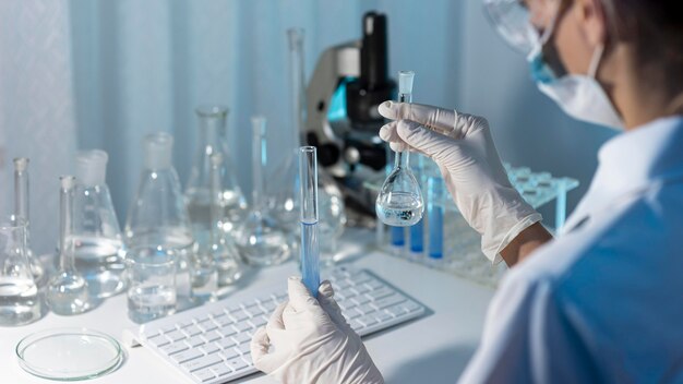 Close-up researcher holding glassware