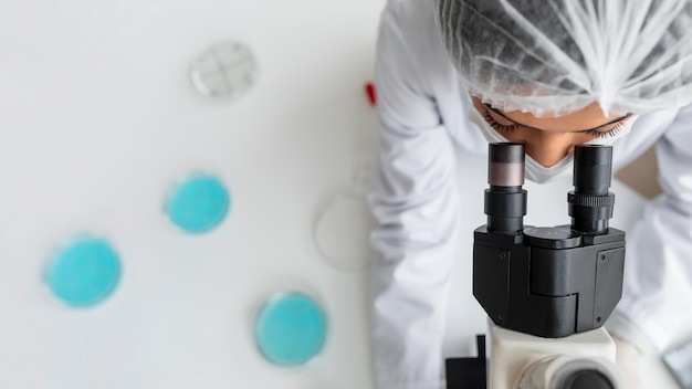 Free photo close up researcher looking through ocular lens