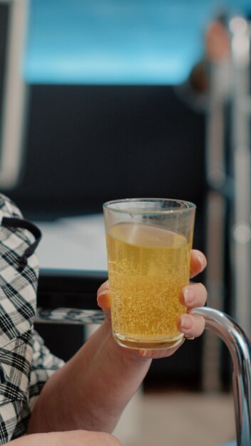 요양원에 앉아 있는 물 한 잔으로 발포성 약을 마시는 은퇴한 여성의 클로즈업. 노인 장애인 환자에게 비타민과 치료를 제공하는 의료 전문가