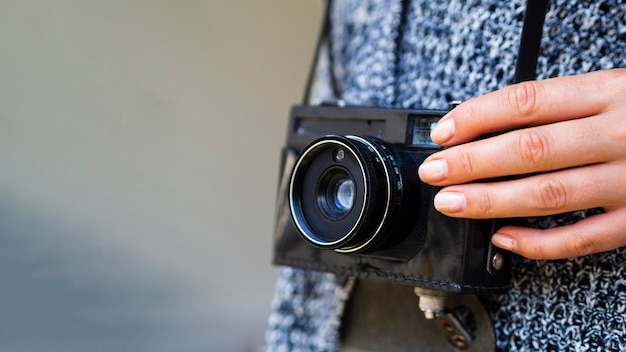 Close-up of a retro photo camera held by a woman