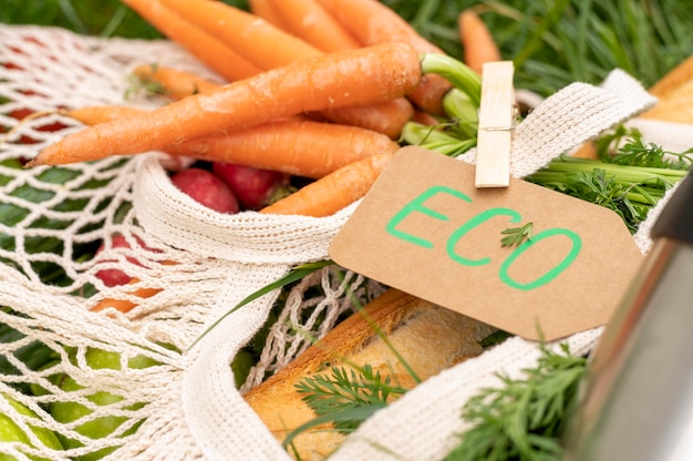 Close-up reusable bag with groceries on grass