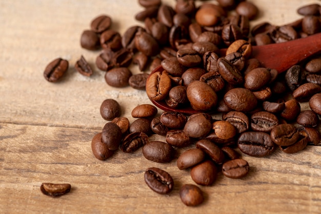 Бесплатное фото Крупный план жареных кофейных зерен с ложкой