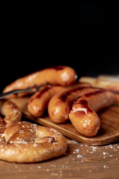 Close-up roasted sausages with pretzel on a table