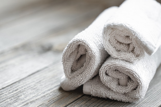 Close up of rolled bath towels on blurred background. Health and personal hygiene concept.