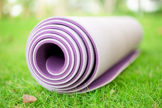 Close-up of rolled exercise mat on grass