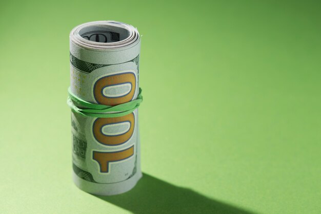 Close-up of rolled up banknotes on green background