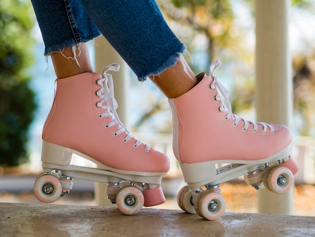 Close-up of roller skates with woman in jeans