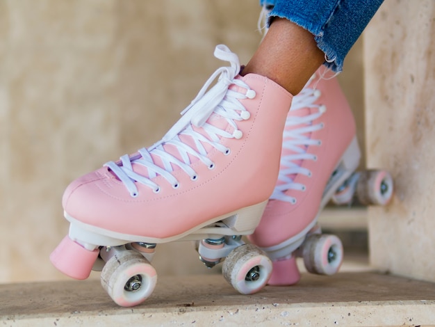 Free photo close-up of roller skates on woman with jeans