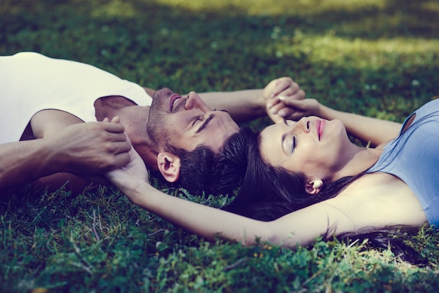 Close-up of romantic couple lying on the grass
