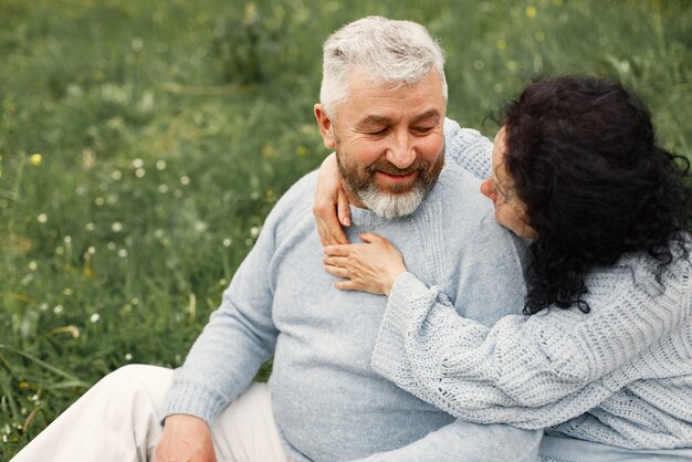 Close up romantic couple sitting in autumn park  and hugging in daytime