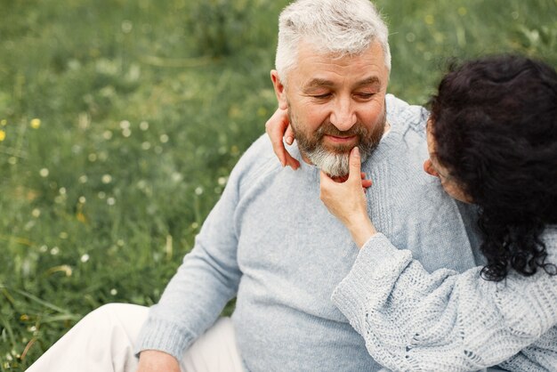 Close up romantic couple sitting in autumn park and hugging in daytime