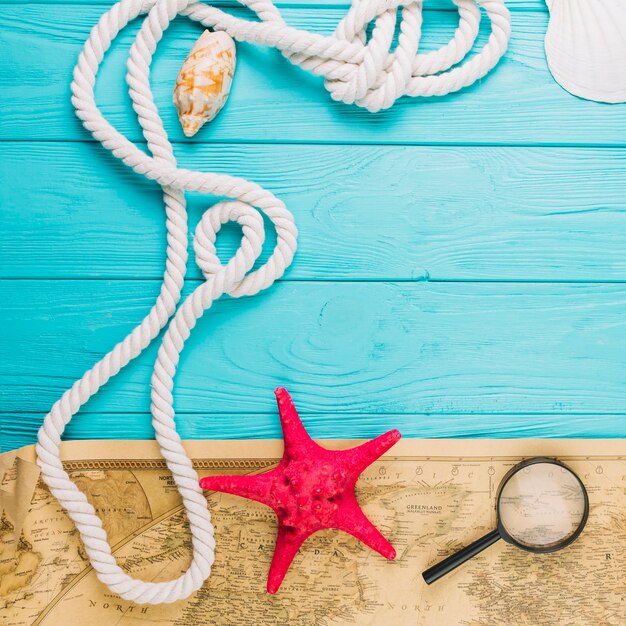 Close-up rope near starfish and map