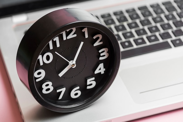 Free photo close-up of round black clock on laptop