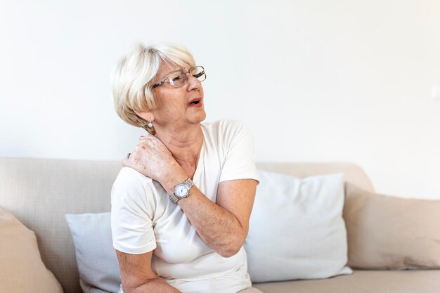 Close up of sad senior lady with neckache Senior woman with chronic pain syndrome fibromyalgia suffering from acute neckaches Senior woman suffering from neck pain