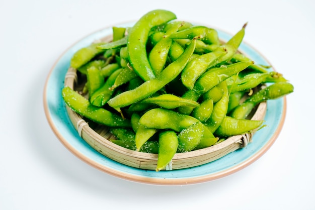 Close up of salted edamame plate in white background
