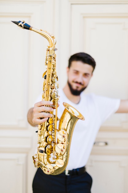 Free photo close up saxophone held by defocused man