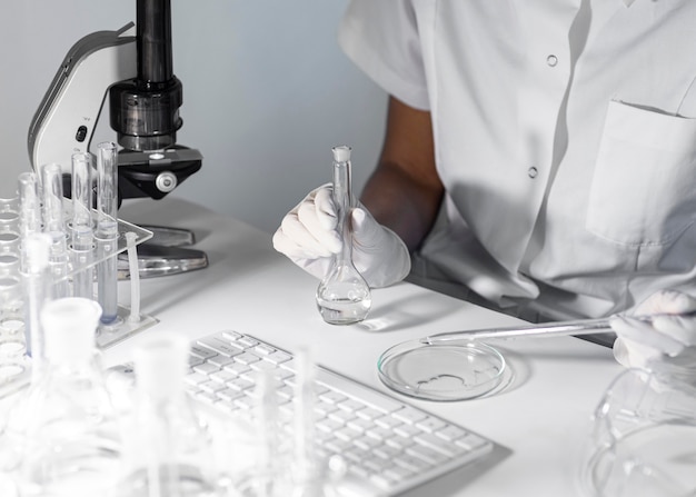 Free photo close-up scientist holding glassware