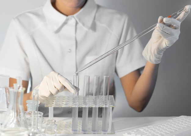 Close-up scientist holding pipette and tube