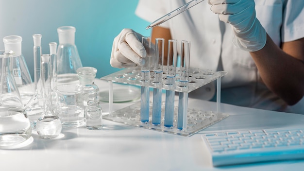 Close-up scientist holding tube and pipette