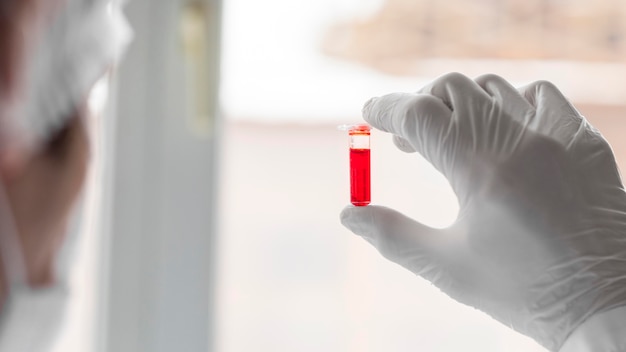 Close up scientist holding tube