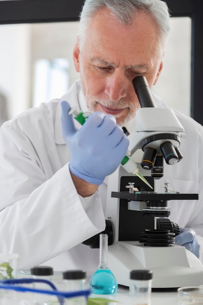 Close up scientist looking through microscope