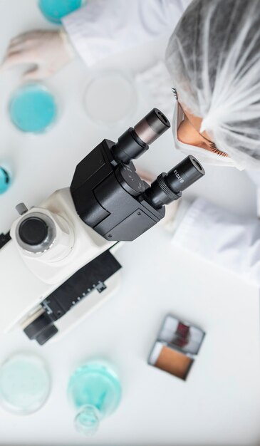 Close up scientist looking through ocular lens