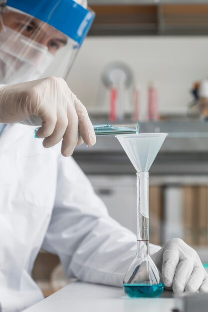 Close up scientist pouring solution